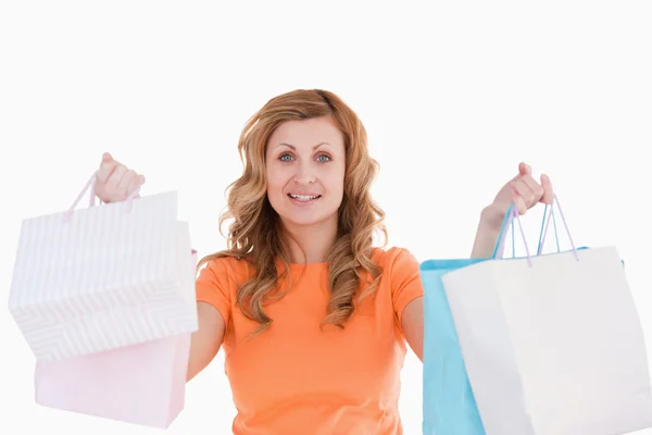 Cute blond-haired woman showing her shopping — Stock Photo, Image
