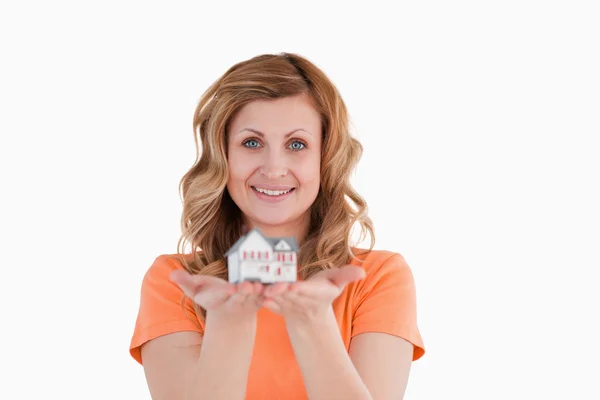 Mujer sonriente sosteniendo un modelo de casa — Foto de Stock