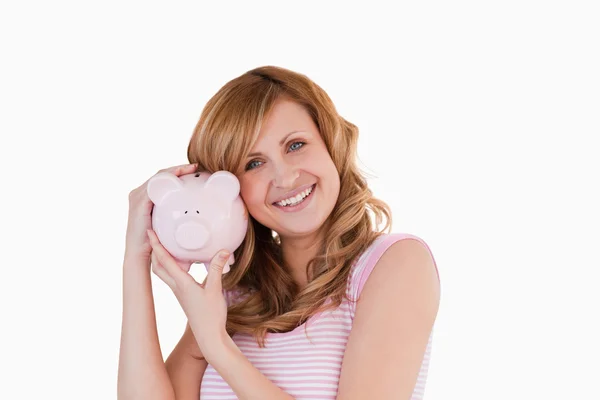 Cute vrouw die lacht terwijl haar spaarpot — Stockfoto