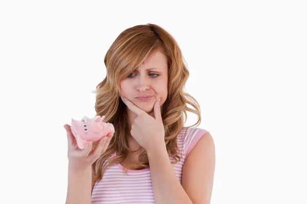 Blond-haired woman confused concerning her broken piggybank — Stock Photo, Image