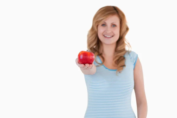 Χαριτωμένο γυναίκα δείχνει ένα κόκκινο μήλο στη φωτογραφική μηχανή — Φωτογραφία Αρχείου