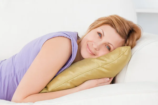 Portrait d'une femme séduisante posant et souriant tout en étant couché o — Photo