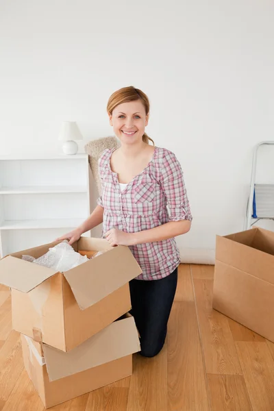 Lachende blonde vrouw voorbereiden op het verplaatsen van huis — Stockfoto