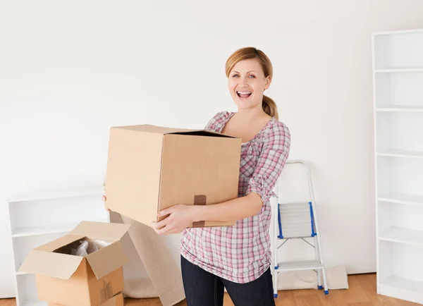 Smiling woman carrying cardboard boxes — Stock Photo, Image