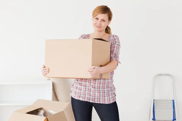 Blond-haired woman carrying cardboard boxes — Stock Photo, Image