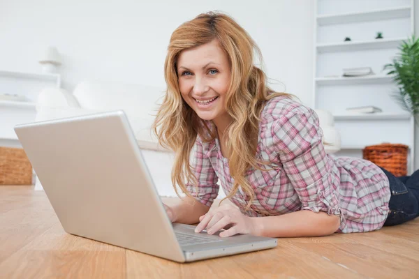Blond-haired woman looking at the camera while chatting on her l — Stock Photo, Image