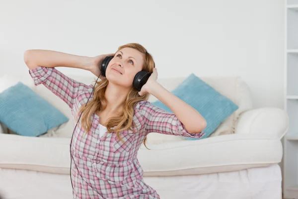 Linda mujer de pelo rubio escuchando música con auriculares — Foto de Stock