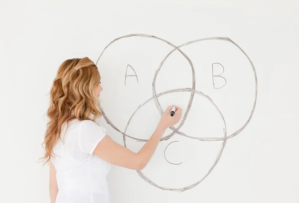 Blond-haired teacher drawing a scheme on a white board — Stock Photo, Image