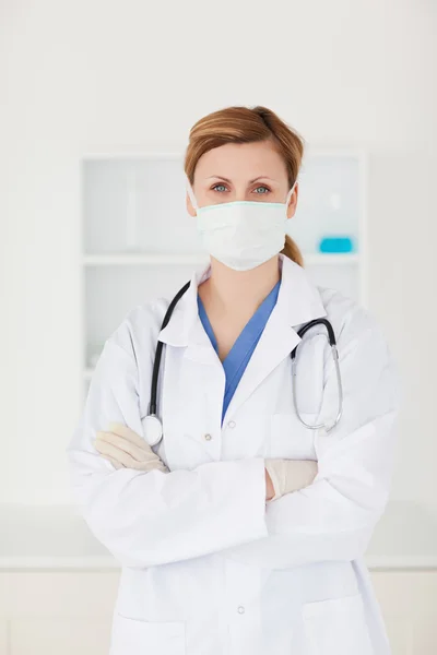 Blond-haired scientist with a mask and a stethoscope looking at — Stock Photo, Image