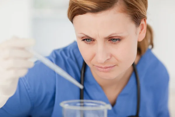 Young female scientist preparing an experiment with a pipette an — Stock Photo, Image