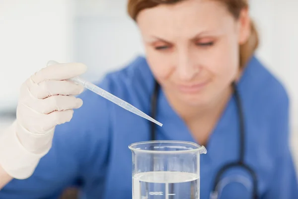 Blond-haired scientist preparing an experiment with a pipette an — Stock Photo, Image