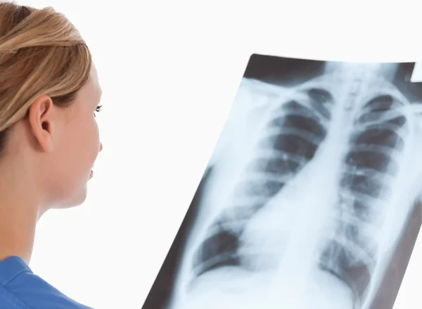 Isolated blond-haired doctor looking at an X-ray — Stock Photo, Image