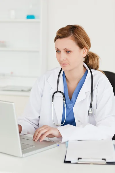 Médico concentrado trabajando en su portátil — Foto de Stock