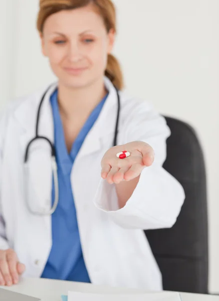 Femme blonde médecin montrant des pilules à la caméra — Photo