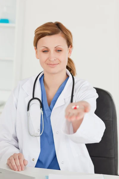Симпатичная женщина-врач показывает таблетки на камеру — стоковое фото