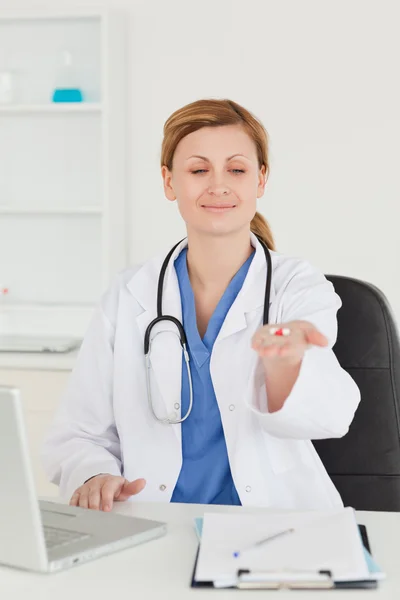 Attraente medico femminile mostrando pillole per la fotocamera — Foto Stock