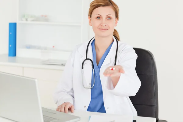 Lächelnde Ärztin zeigt Tabletten in die Kamera — Stockfoto