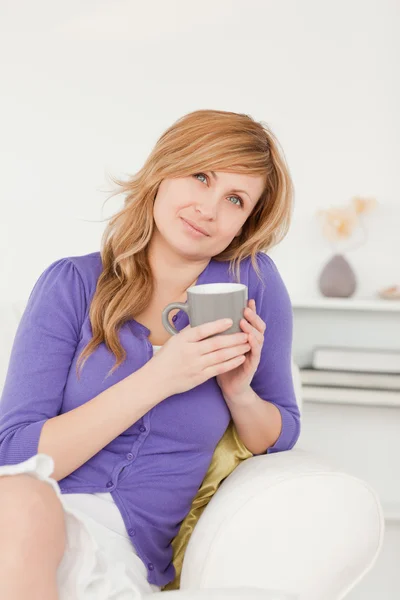 Attractive red-haired woman holding a cup of coffee while sittin — Stock Photo, Image