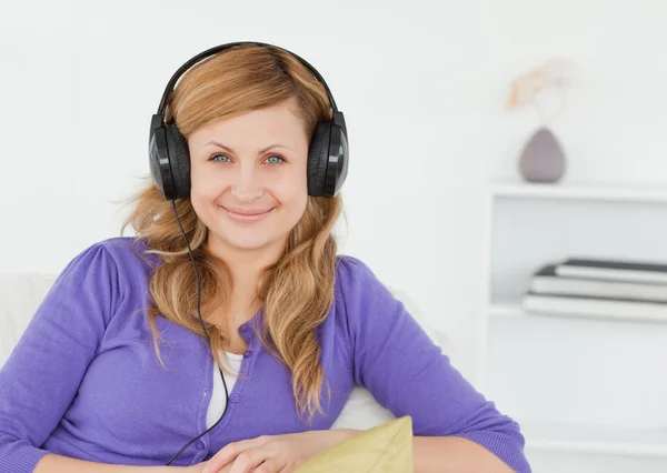 Vacker rödhårig kvinna lyssna på musik och poserar samtidigt s — Stockfoto