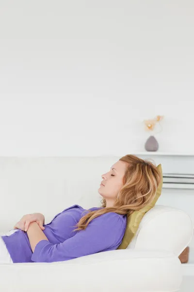 Hermosa mujer descansando tumbada sobre su espalda en un sofá —  Fotos de Stock