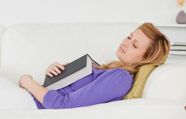 Vacker kvinna liggande på soffan som har fallit i sömn medan re — Stockfoto