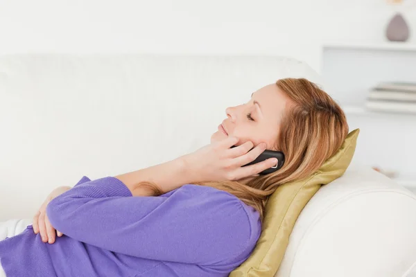 Portrait de profil d'une femme aux cheveux roux tranquille au téléphone alors que lyin — Photo
