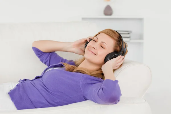 Przystojny rudowłosa kobieta, słuchania muzyki i korzystania th — Zdjęcie stockowe