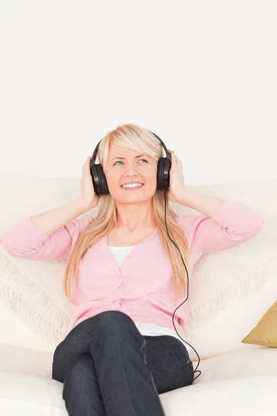 Güzel bir kadın onun kulaklık sitti ise müzik dinlemek — Stok fotoğraf