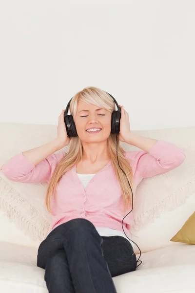 Piękna kobieta, słuchanie muzyki na jej słuchawki podczas sitt — Zdjęcie stockowe