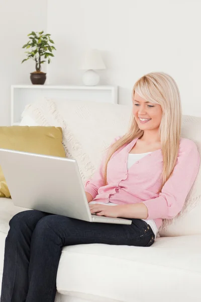 Jovem bela mulher relaxante com um laptop enquanto sentado em um — Fotografia de Stock