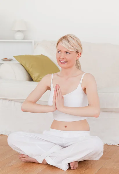 Ung attraktiv kvinna gör yoga i vardagsrummet — Stockfoto