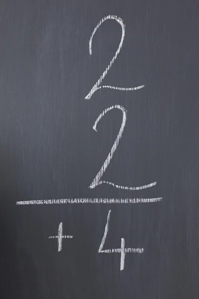 Blackboard with a simple fraction written on it — Stock Photo, Image