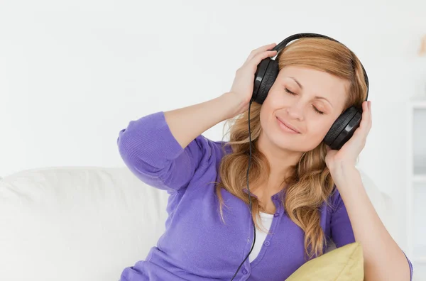 Beautiful red-haired woman listening to music and enjoying the m — Stock Photo, Image