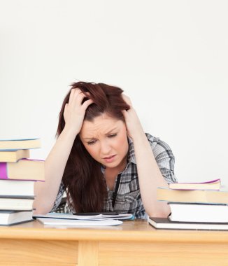 Attractive red-haired female being depressed while studying for clipart