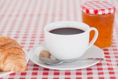 Continental breakfast with croissant, jam and coffee on a tablec clipart