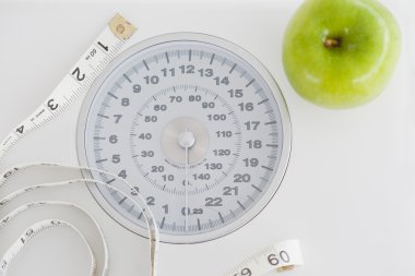 Top view of a green apple along with a tape measure and a weigh- clipart