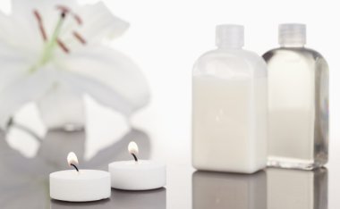 White orchid glass flasks and lighted white candles clipart