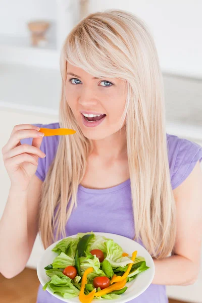 Bela fêmea sorridente comendo sua salada — Fotografia de Stock