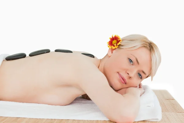 Schöne blonde Frau entspannt sich mit heißen Steinen auf dem Rücken — Stockfoto