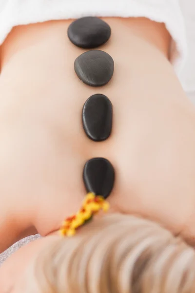 Donna bionda rilassante con pietre calde sulla schiena — Foto Stock