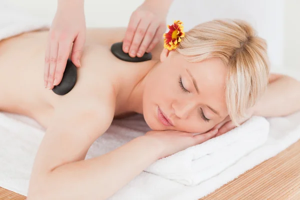 Junge Frau erhält eine Massage mit heißen Steinen — Stockfoto