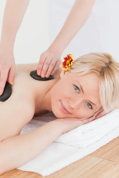 Mulher atraente recebendo uma massagem com pedras quentes — Fotografia de Stock