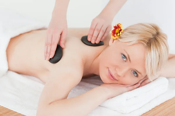 Niedliche Frau erhält eine Massage mit heißen Steinen — Stockfoto