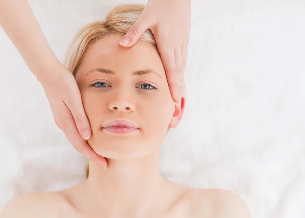 Mulher de cabelos loiros recebendo uma massagem no rosto — Fotografia de Stock