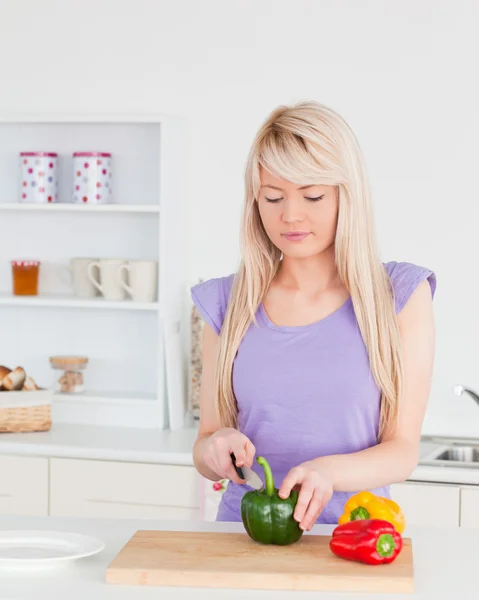 Atractiva mujer rubia cortando verduras en la cocina moderna int — Foto de Stock