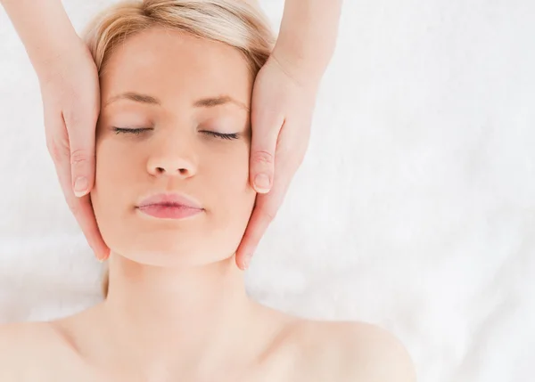 Glad blond kvinna får en massage på hennes ansikte — Stockfoto