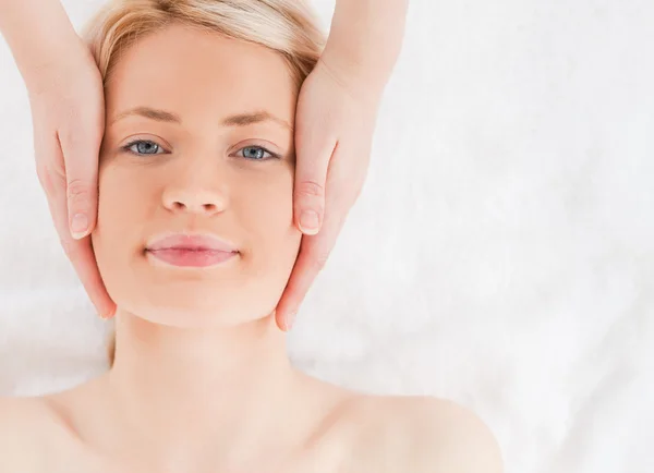 Felice donna dai capelli biondi ottenere un massaggio sul suo viso — Foto Stock