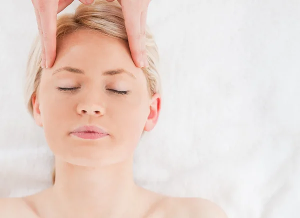 Young blond-haired woman getting a massage on her face — Stock Photo, Image