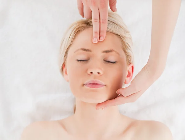 Atractiva mujer rubia recibiendo un masaje en su cara —  Fotos de Stock