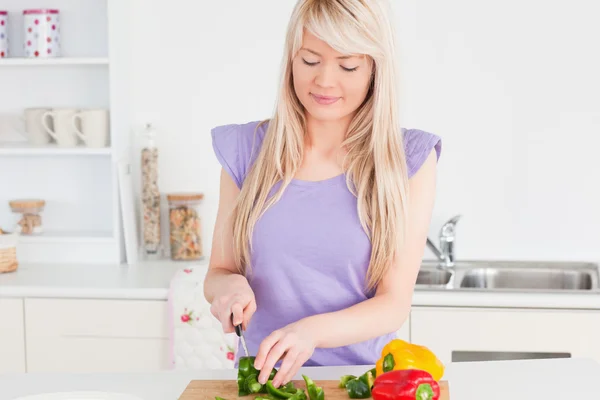 Hermosa hembra rubia cortando verduras en la cocina moderna int —  Fotos de Stock